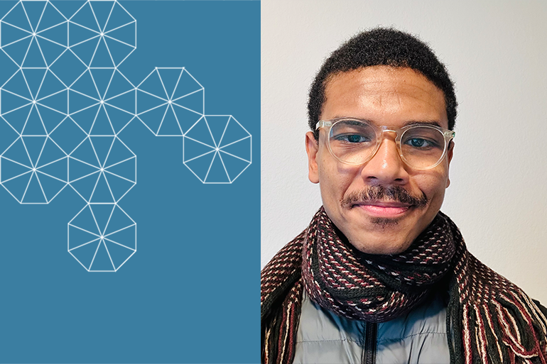 Graduate Student Researcher Aqshems Nichols smiling, wearing glasses and a dark woolen scarf