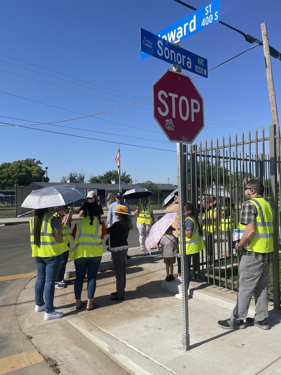 A facilitator leads a walking and biking assessment in Tulare, California that included adult and school-aged participants.