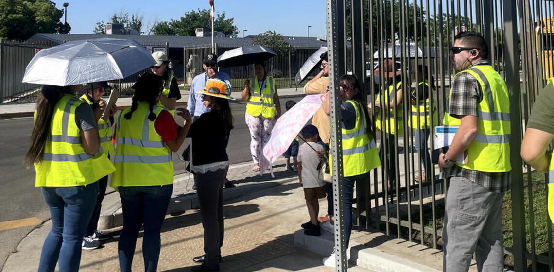 Adults and youth wear safety vests and participate in a walking and biking assessment.