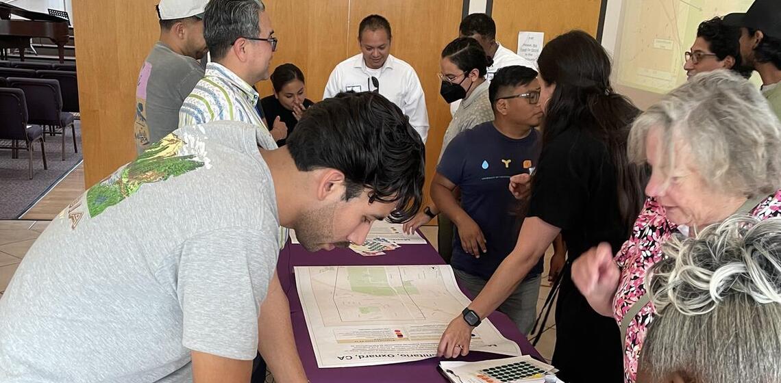 A group of adults participate in a mapping activity at a workshop.