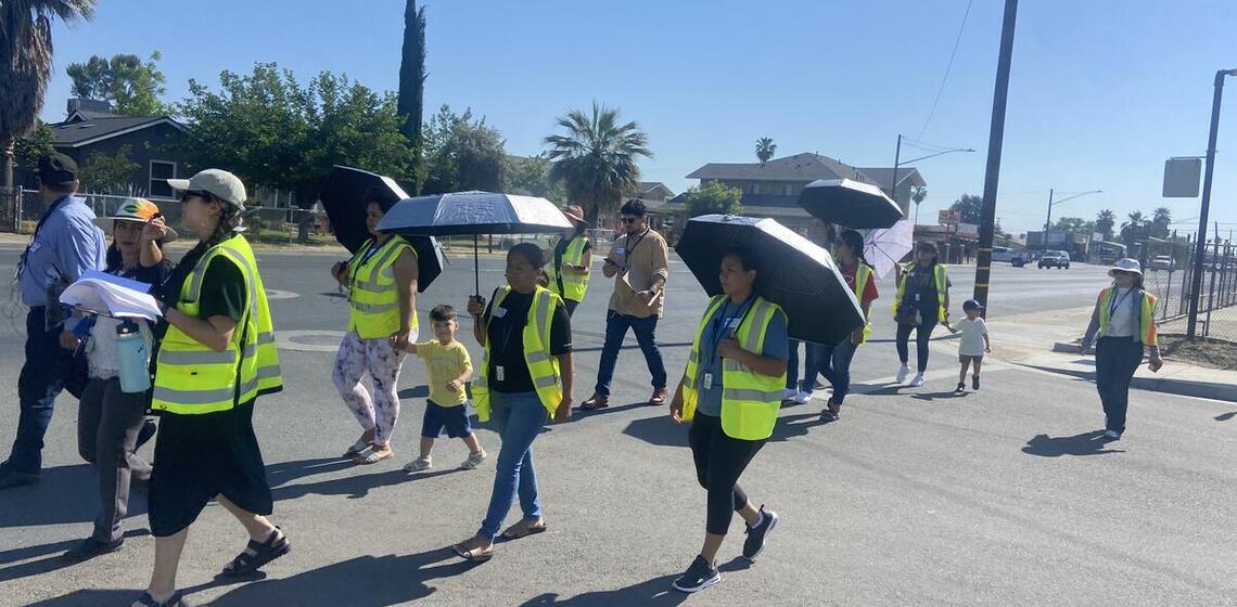 Adults and youth wearing safety vests participate in a walking and biking assessment.