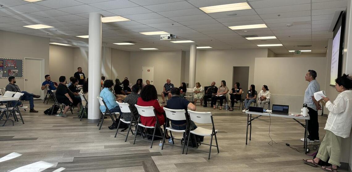Instructors lead a discussion for a large group at a workshop.