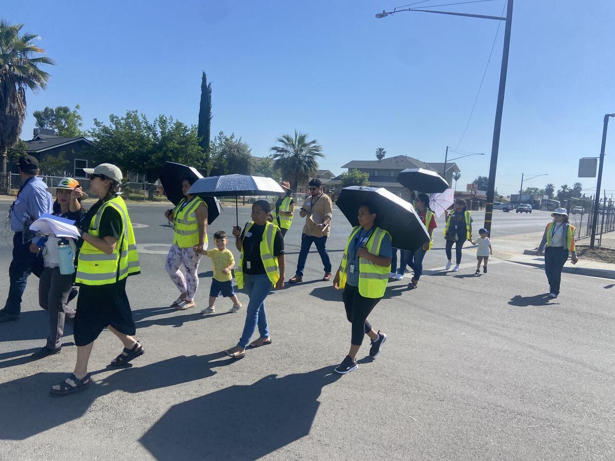  Adults and youth wearing safety vests participate in a walking and biking assessment. 