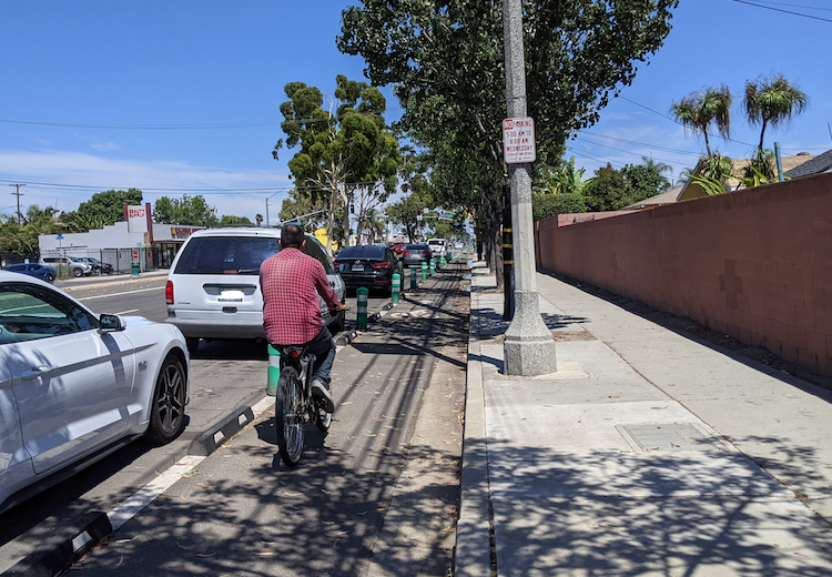 Man bicycling in a bike lane in North Long Beach, CA