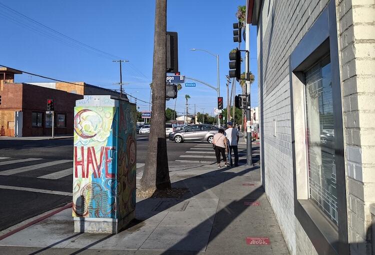 A woman and a man wait to cross the intersection on Avalon Blvd. in Wilmington, CA