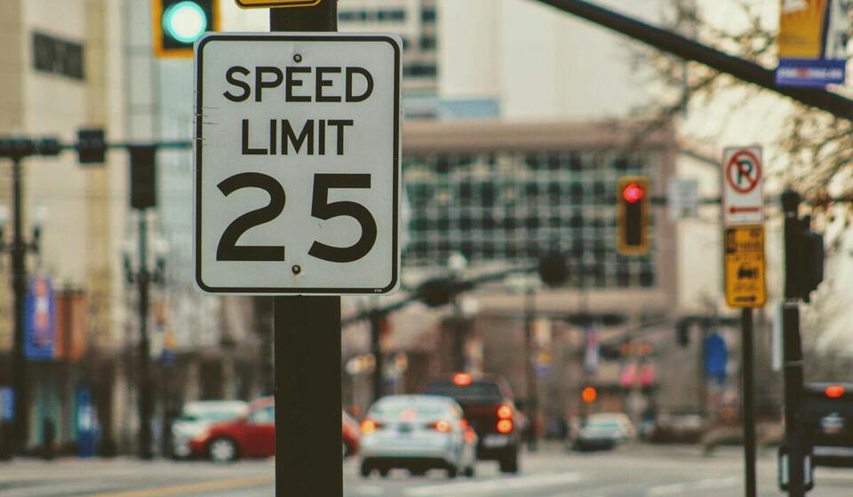 City street view with a speed limit sign reading "Speed Limit 25"