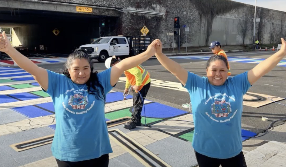 Los Angeles Walks Promotoras Leads Gaby Segovia and Nancy Cid raising their arms celebrating the installation of a crosswalk.