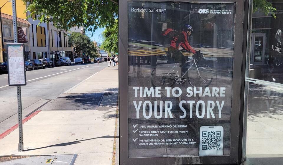 A bus stop poster on Bancroft, near UC Berkeley, shows a bicyclist with the call overlaid "Time to Share Your Story"