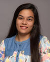 CPBS Fellow Miasma Mollika Mita faces the camera smiling in a blue and floral print blouse