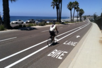 Bicyclist traveling down bike lane near the California Coast.