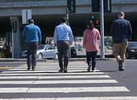 Four people in crosswalk at busy intersection
