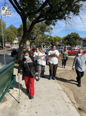 SafeTREC's Areli Balderrama conducts a walk assessment in Boyle Heights with a group of 12 participants on a neighborhood street