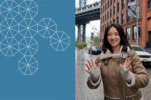 Sujin Lee smiles towards the camera on a city street with a bridge in the background