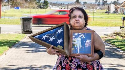 Debbie Colquitt holds a photo of her father Edward Villasenor, who was struck and killed outside his Elk Grove home the night the family celebrated her parents’ 49th wedding anniversary, as a car speeds past the property in March. 